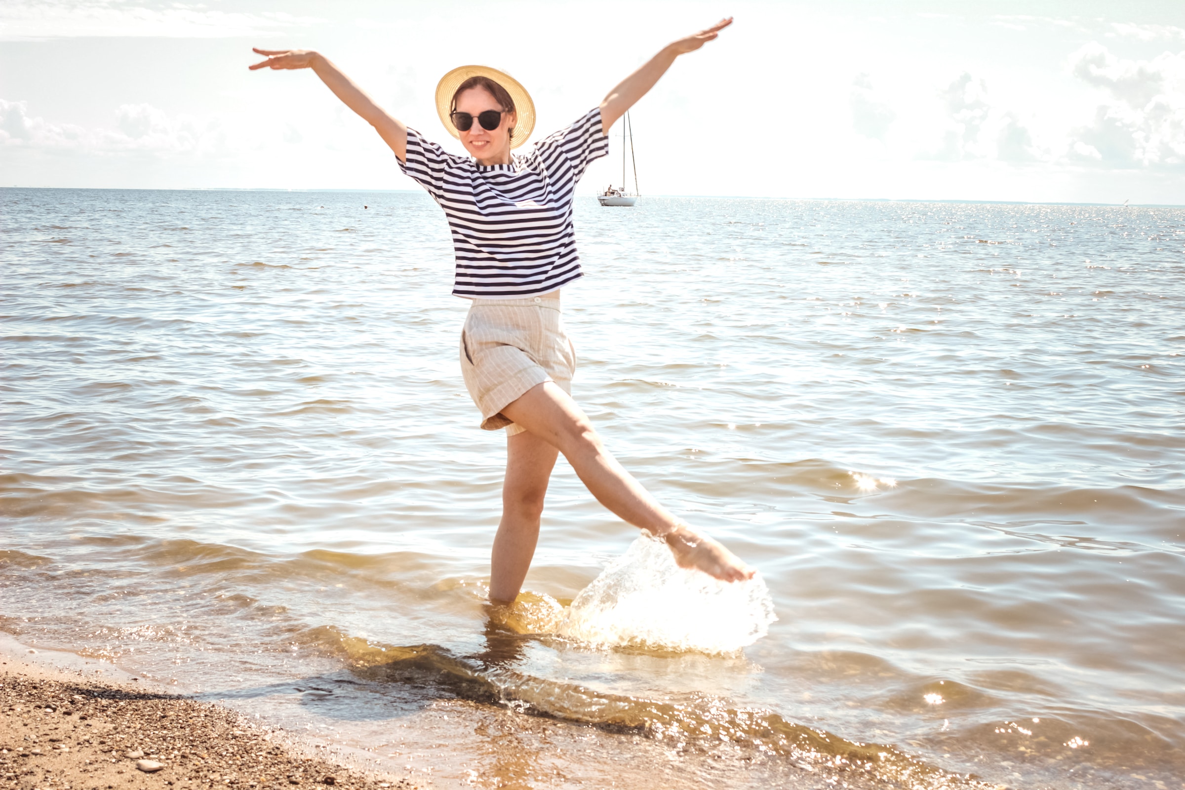 Woman in hat standing by the seashore