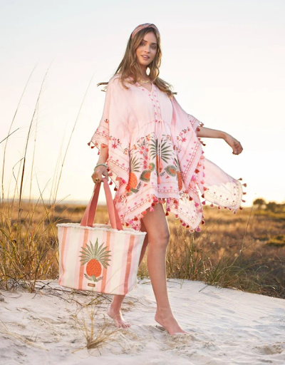 woman on beach wearing Spartina 449 pineapple beach cover-up and carrying beach bag
