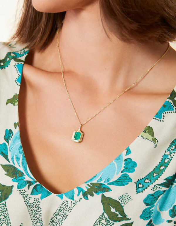 a woman wearing an ocean green pendant necklace