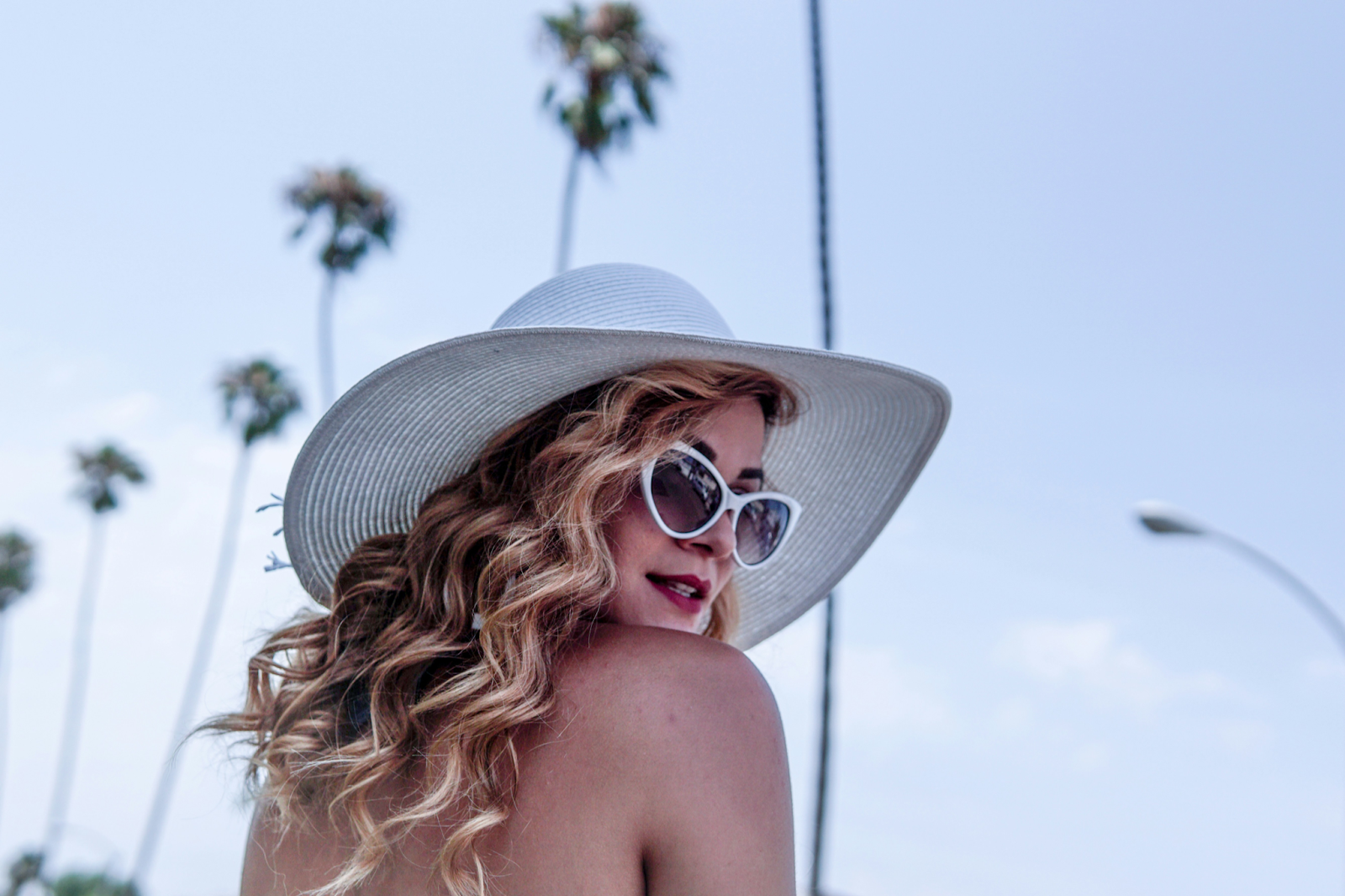 woman wearing white sunglasses and sun hat